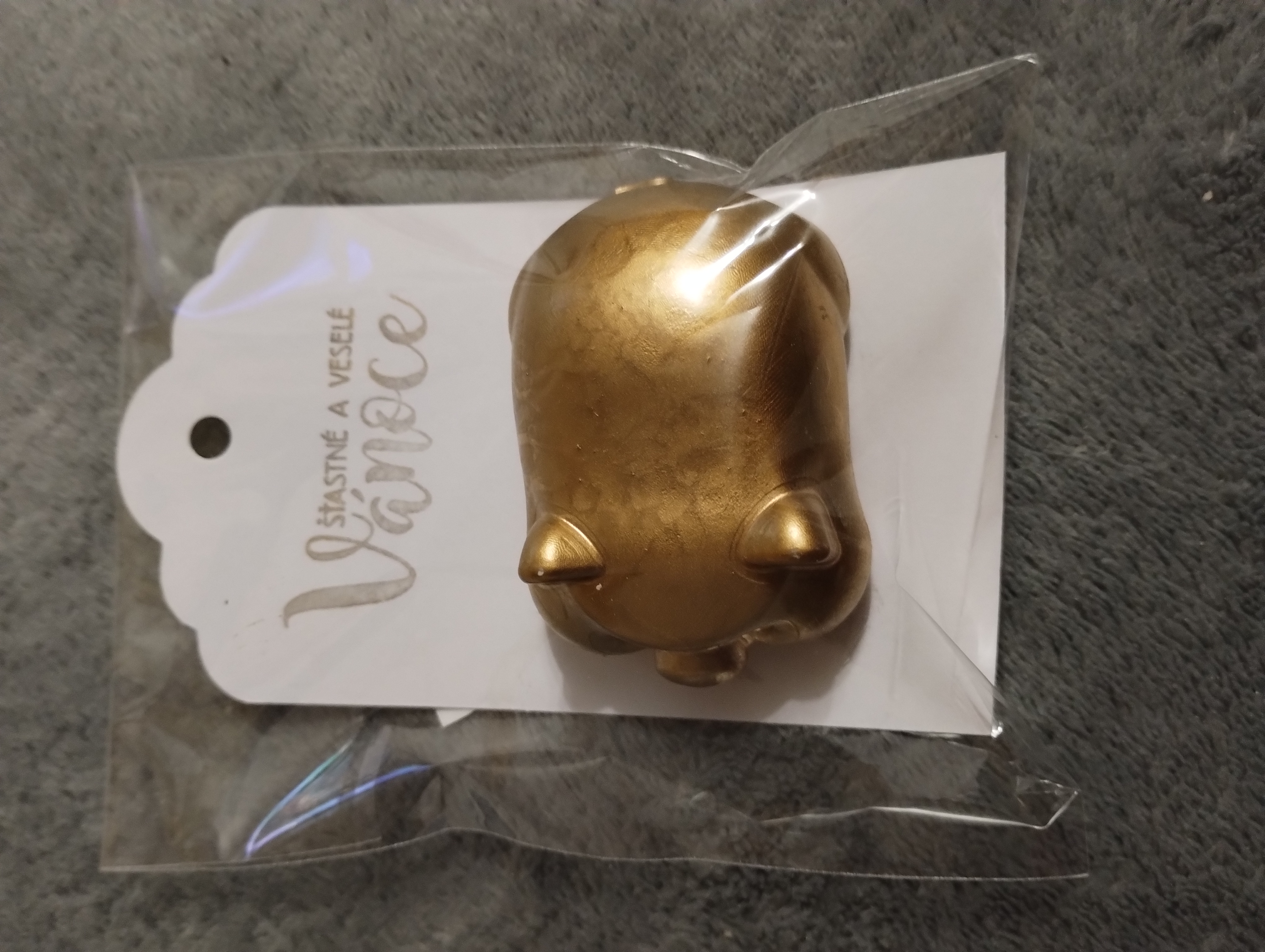 Prasátko zlaté barvy s nápisem Šťastné a veselé Vánoce 